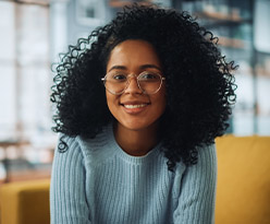 A smiling woman sitting in a chair.