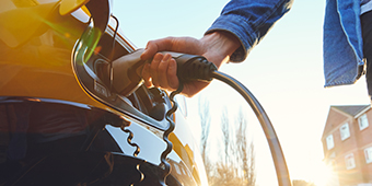 A person is charging an electric car with a charger