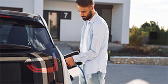 A man is charging his electric car at a charging station