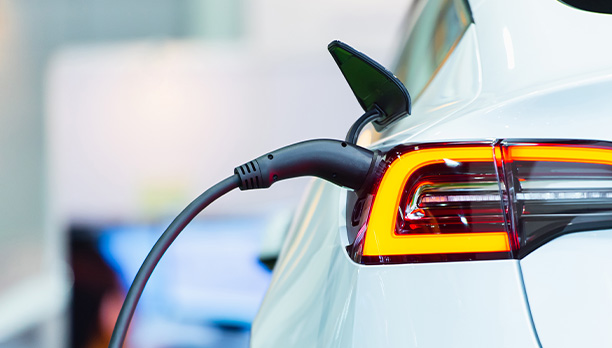 A white electric car is being charged at a charging station