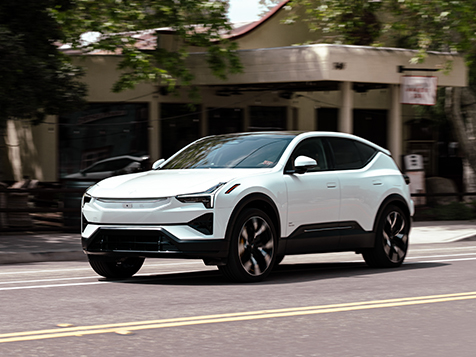 White Polestar 3 driving down a city street