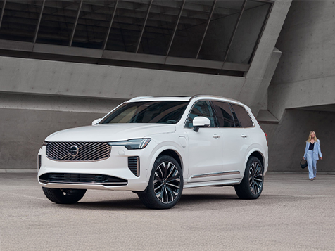 a white Volvo XC90 parked outside an industiral building