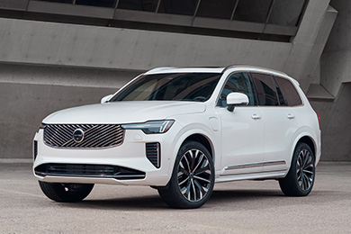 White Volvo XC90 is parked outside an industrial building