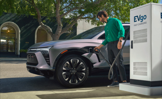 A man is charging his Chevrolet Blazer EV at an EVgo charging station