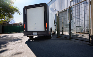 Rear of a Chevrolet BrightDrop truck parked near a truck loading dock