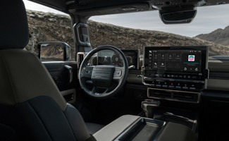 The interior of a GMC HUMMER EV SUV with a steering wheel and a dashboard