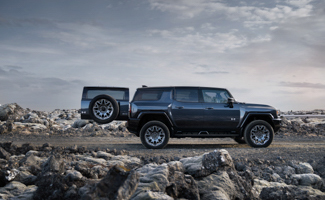 A black GMC Hummer EV SUV parked on a rocky road