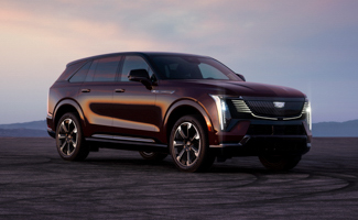 A maroon Cadillac ESCALADE IQ is parked in the middle of a desert