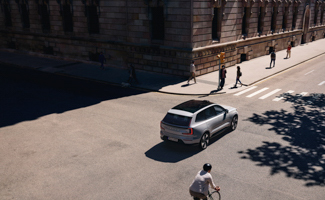 A Volvo EX90 is stopped at a crosswalk on the street