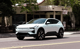 a white Polestar 3 driving down a neighborhood street