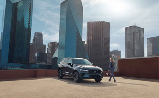 Grey Volvo XC60 parked on the roof with cityscape behind