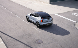 A silver Volvo EX30 driving down a road