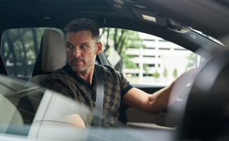 A closeup of a man in the drivers seat of a Volvo XC60