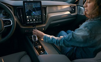 A passenger in the front seat of the Volvo XC60 featuring the infotainment screen