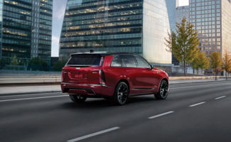Red Cadillac VISTIQ driving through a city