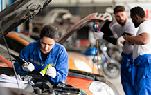 A group of mechanics are working on a car in a garage